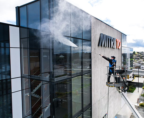 Man providing commercial building washing services to Mitre 10 office